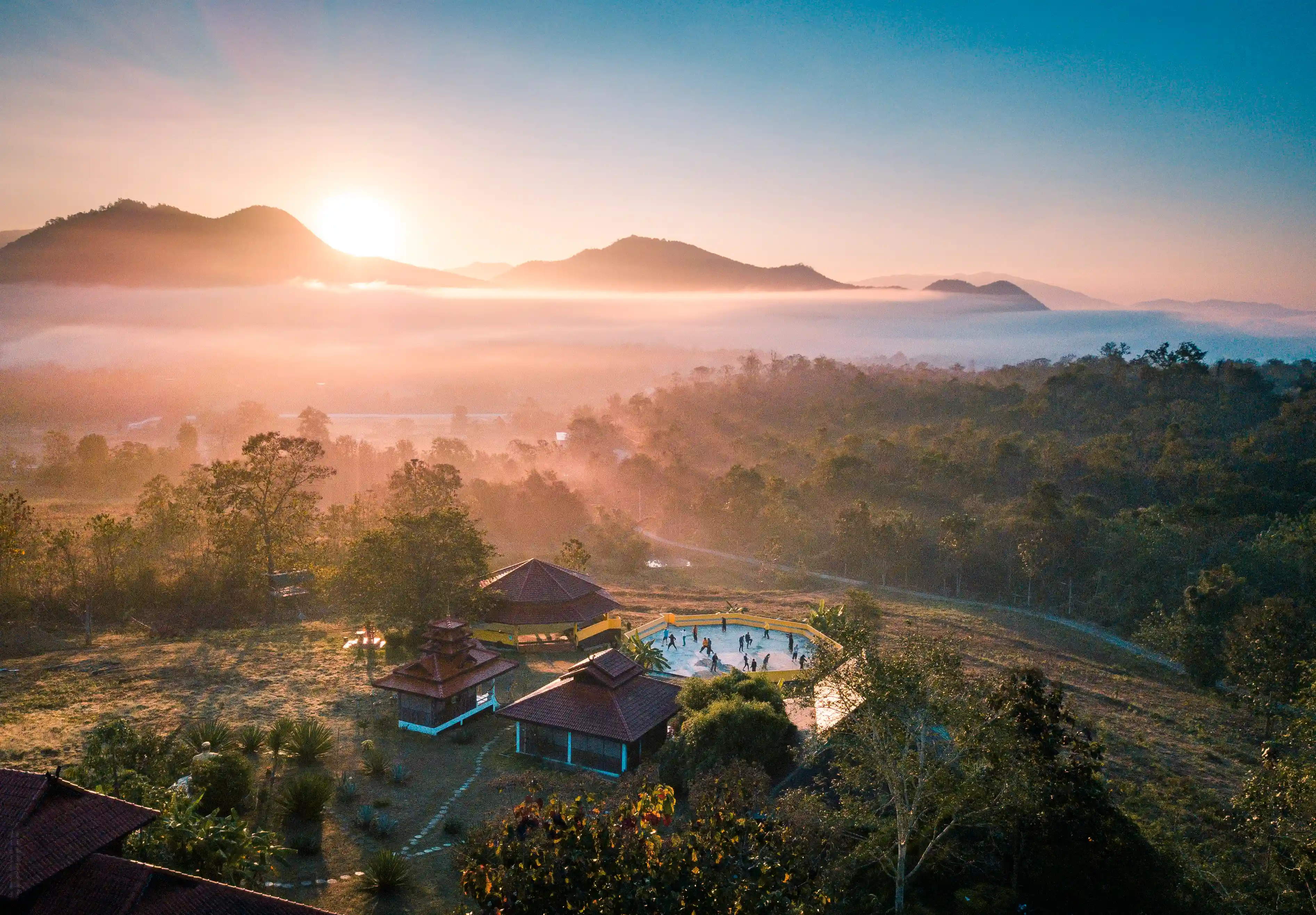 Aerial sunrise view of the Nam Yang Kung Fu Retreat in Pai, Thailand, overlooking the surrounding mountains