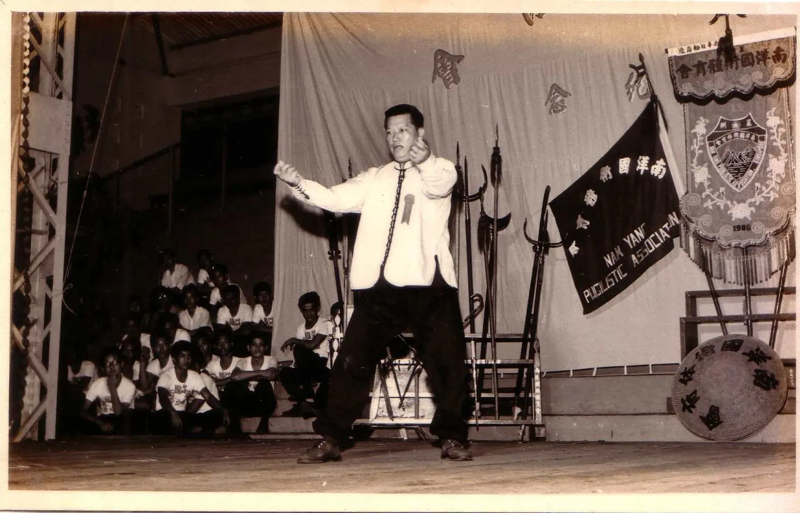 Historical Nam Yang demonstration with banner and traditional audience visible