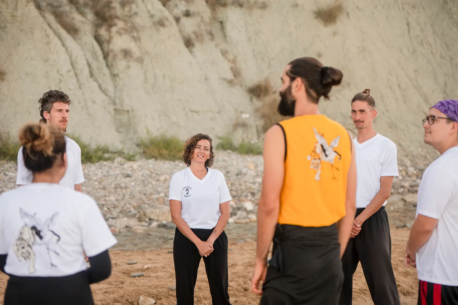Students standing together on the beach before practice, sharing a relaxed moment as a group